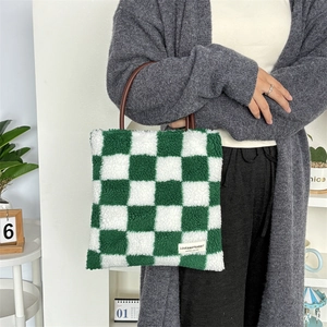 Gros plan détaillé du sac cabas en peluche à damier vert avec poignées en cuir