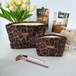 Detail of leopard print suede makeup bag set with zip closure and fabric brand label