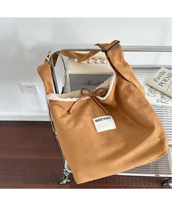 Close-up of brown suede tote bag featuring plush white fleece lining and drawstring detail