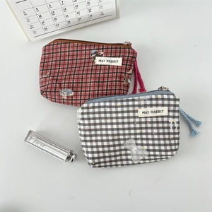Detailed view of plaid canvas pouches with cute animal prints and secure zipper pulls