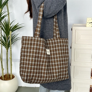 Détail du sac cabas en laine à carreaux vintage montrant la texture et l'étiquette