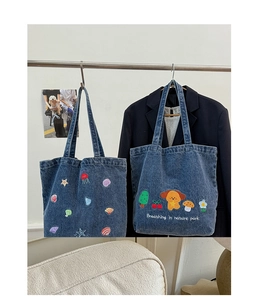 Close-up of colorful ocean and dog embroidery on large navy denim canvas tote bag
