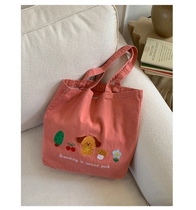 Close-up of pink canvas tote bag featuring cute cartoon embroidery and nature park slogan