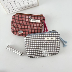 Detail of plaid mini canvas bags with cute cartoon patches and colorful zipper pulls
