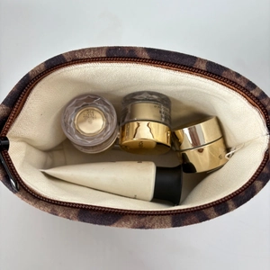 Macro view of leopard print suede makeup bag showing spacious interior with skincare items