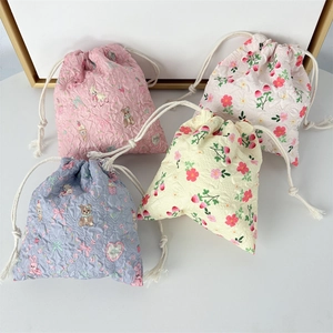 Mini cartoon drawstring storage pouches in four pastel colors with quilted fabric texture