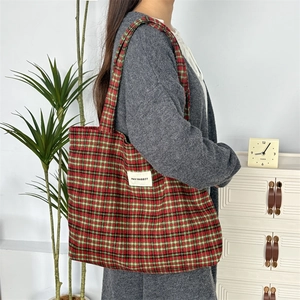 Sac fourre-tout classique en laine à carreaux rouges et verts avec étiquette sur l'épaule