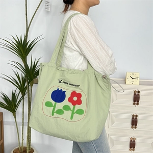 Detailansicht der hellgrünen Canvas-Einkaufstasche mit Blumenstickerei und Kordelzug