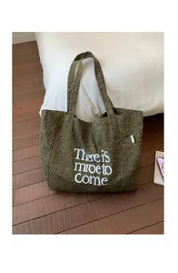 Close-up of leopard print canvas tote bag in army green with white artistic lettering