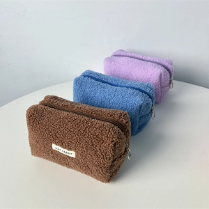 Detail of soft teddy fleece pencil bags in brown, blue and purple with metal zippers