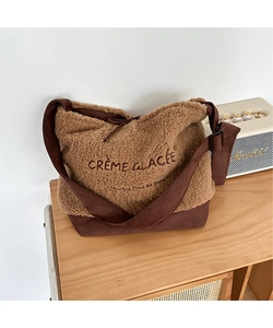 Detail of suede and faux shearling tote bag with Crème Glacée embroidery on table