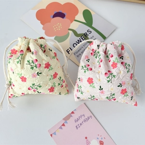 Close-up of floral drawstring pouches in yellow and pink jacquard cotton fabric