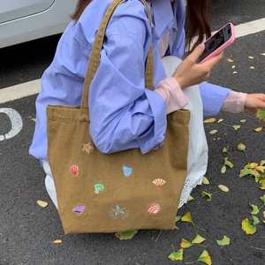 Canvas tote bag with colorful starfish embroidery and Star Fish text on model