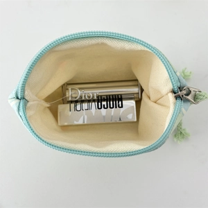 Internal view of a small canvas makeup bag with light blue patterns and zipper detail