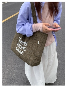 Detailed view of dark brown leopard print canvas tote bag with white lettering art