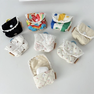 Flat lay of quilted floral headphone pouches with lace trim and secure snap closure