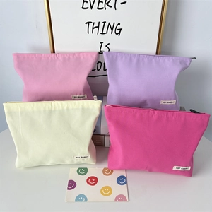 Detail of four colorful thick canvas makeup bags with zippers and May Rabbit fabric tags