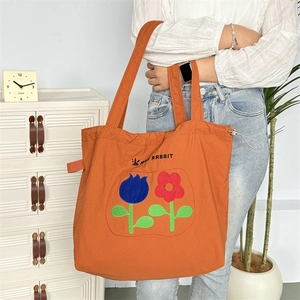 Orangefarbene Nylon-Kordelzugtasche mit Blumenstickerei und Happy Rabbit Aufdruck
