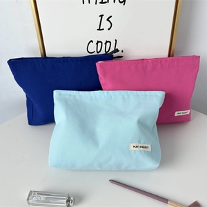 Detailed view of durable thick canvas toiletry bags in navy, pink, and light blue