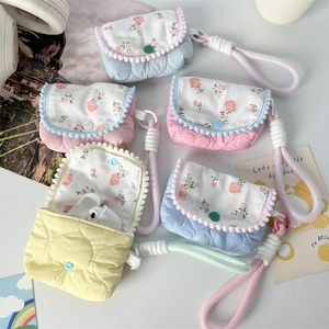 Detailed view of quilted floral mini pouches with scalloped trim and wrist straps