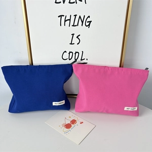 Detailed close-up of blue and pink canvas cosmetic bags with durable black zippers