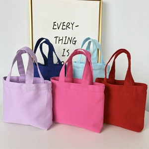 Detailed row of colorful small canvas tote bags in purple, blue, pink, and red