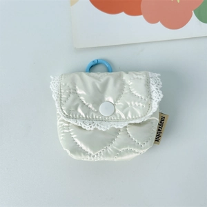 Detail der weißen gesteppten Kopfhörertasche mit Herzmuster, Spitze und blauem Clip