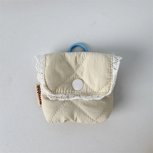 Close-up of cream quilted headphone case with lace trim and blue hanging ring