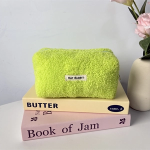 Detail of soft neon green teddy fleece pencil case with woven label on decorative books