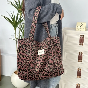 Gros plan du sac cabas léopard rose avec texture pelucheuse douce et étiquette logo blanche