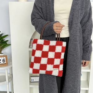 Gros plan du sac cabas en peluche à damier rouge et blanc avec anses rondes marron