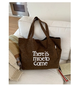 Detail of leopard print tote bag on white sofa with 'There is more to Come' white text