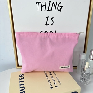 Detailed close-up of pink canvas makeup bag with premium zipper and May Rabbit brand label
