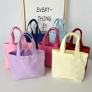 Detailed pile of colorful canvas mini tote bags in purple, yellow, pink and blue