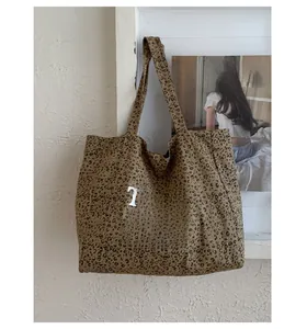 Detail of leopard print canvas tote bag featuring white letter print and durable strap