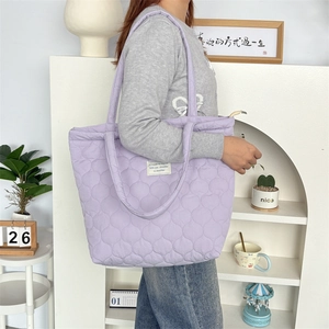 Seitenansicht der großen violetten Stepp-Tragetasche mit weicher Wattierung und Aufnäher