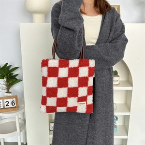 Détail du sac cabas à damier rouge en peluche douce avec poignée en cuir marron chic