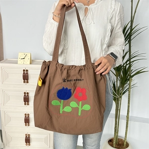 Nahaufnahme braune Nylon-Tragetasche mit Tulpenstickerei und May Rabbit Branding