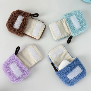 Flat lay of four colorful plush earphone cases in brown, blue, purple, and royal blue