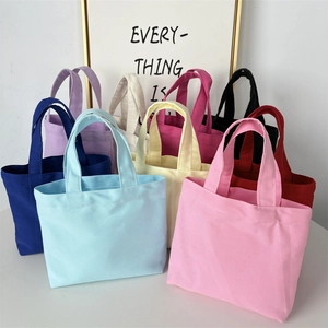 Collection of minimalist canvas tote bags in nine vibrant colors on a clean white desk