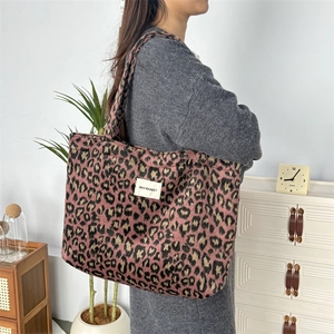 Détail du cabas en peluche imprimé léopard rose avec étiquette May Rabbit sur l'épaule