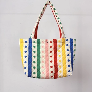 Dettaglio di borsa tote trapuntata a righe colorate con motivi floreali e fibbia