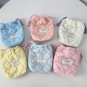 Multiple colorful quilted drawstring pouches for camera storage in pastel macaroon shades