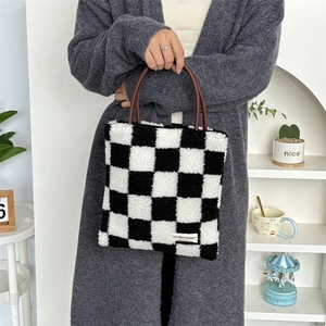 Gros plan du sac cabas à damier en peluche douce avec une poignée en similicuir chic