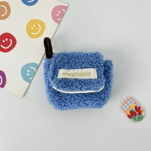 Detailed macro of blue fluffy faux fur AirPods case with Mayrabbit label and tulip decor