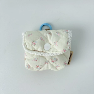 Close-up of quilted floral earphone case featuring white lace trim and resin button detail