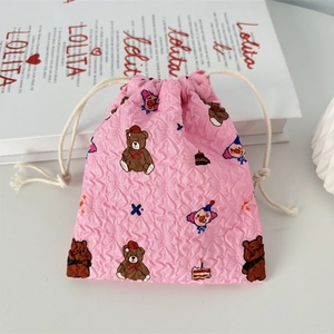 Detail of pink bubble texture fabric on drawstring pouch with cute cartoon embroidery