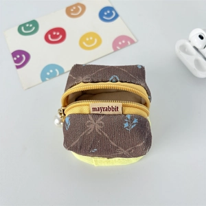 Close-up of brown corduroy mini storage bag with blue floral patterns and pearl detail