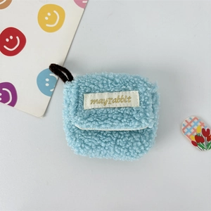 Close-up of soft sky blue plush earphone case with gold embroidered mayrabbit cloth label