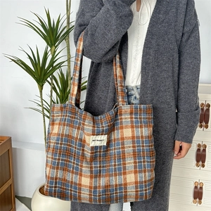 Détail du grand sac cabas à carreaux orange et bleu avec étiquette de marque en situation